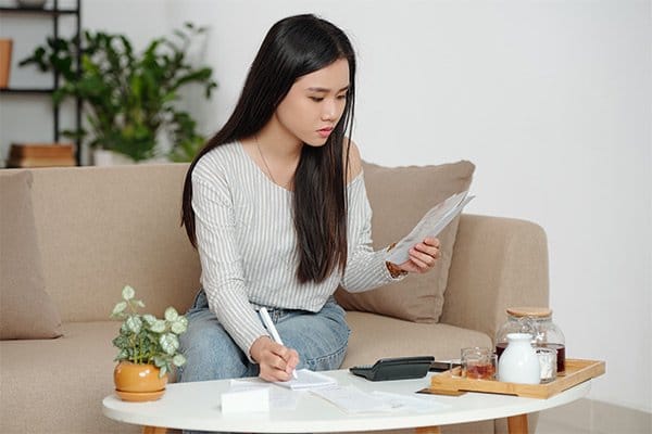 Woman on sofa calculating finances
